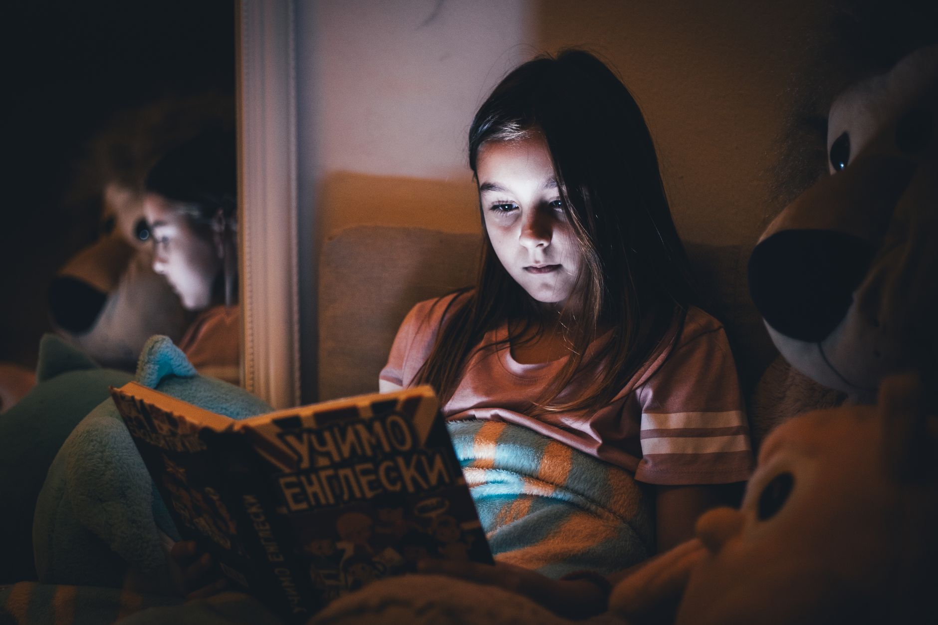 A child reading calmly in bed as part of an evening routine
