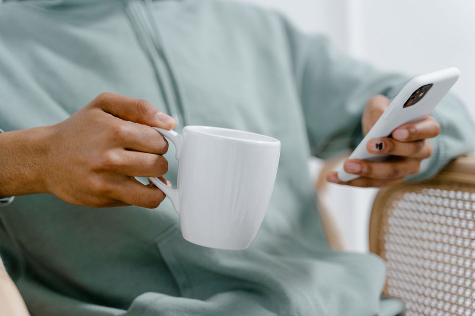 A parent relaxing with coffee and their phone, no ads in sight