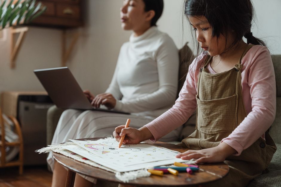 A parent working calmly while their child gets on with their own task nearby
