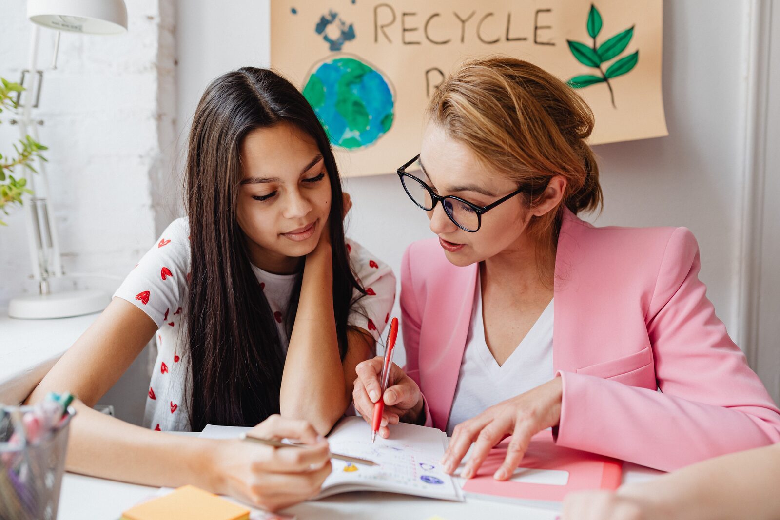 A parent and a middle schooler going over missed practice questions together at a desk