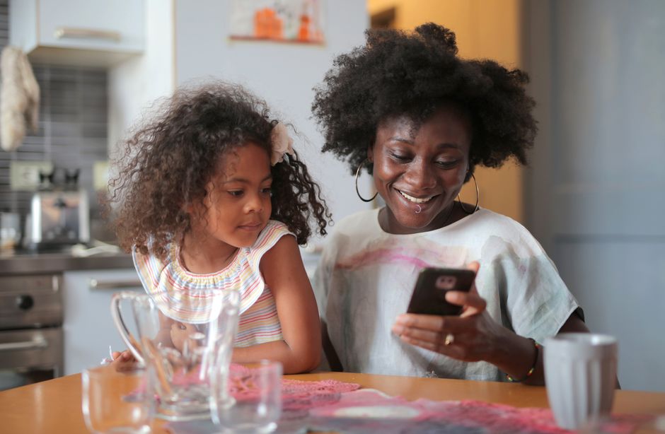 A parent checking the family calendar on their phone in the kitchen